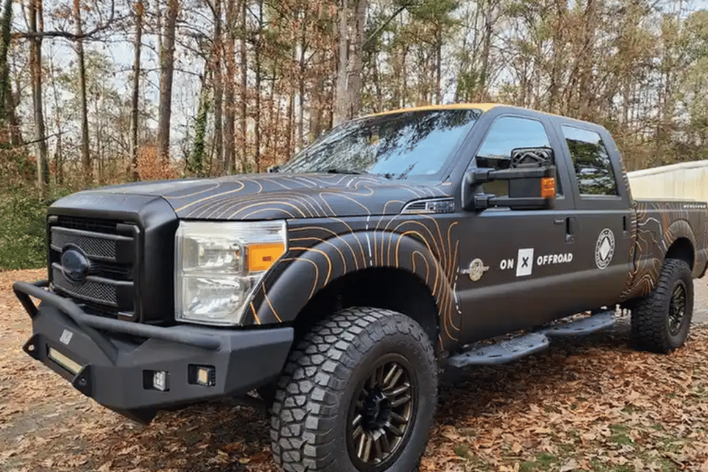 Custom wrapped Ford Super Duty truck parked outdoors, illustrating how climate, sun exposure, and daily use affect vehicle wrap lifespan.
